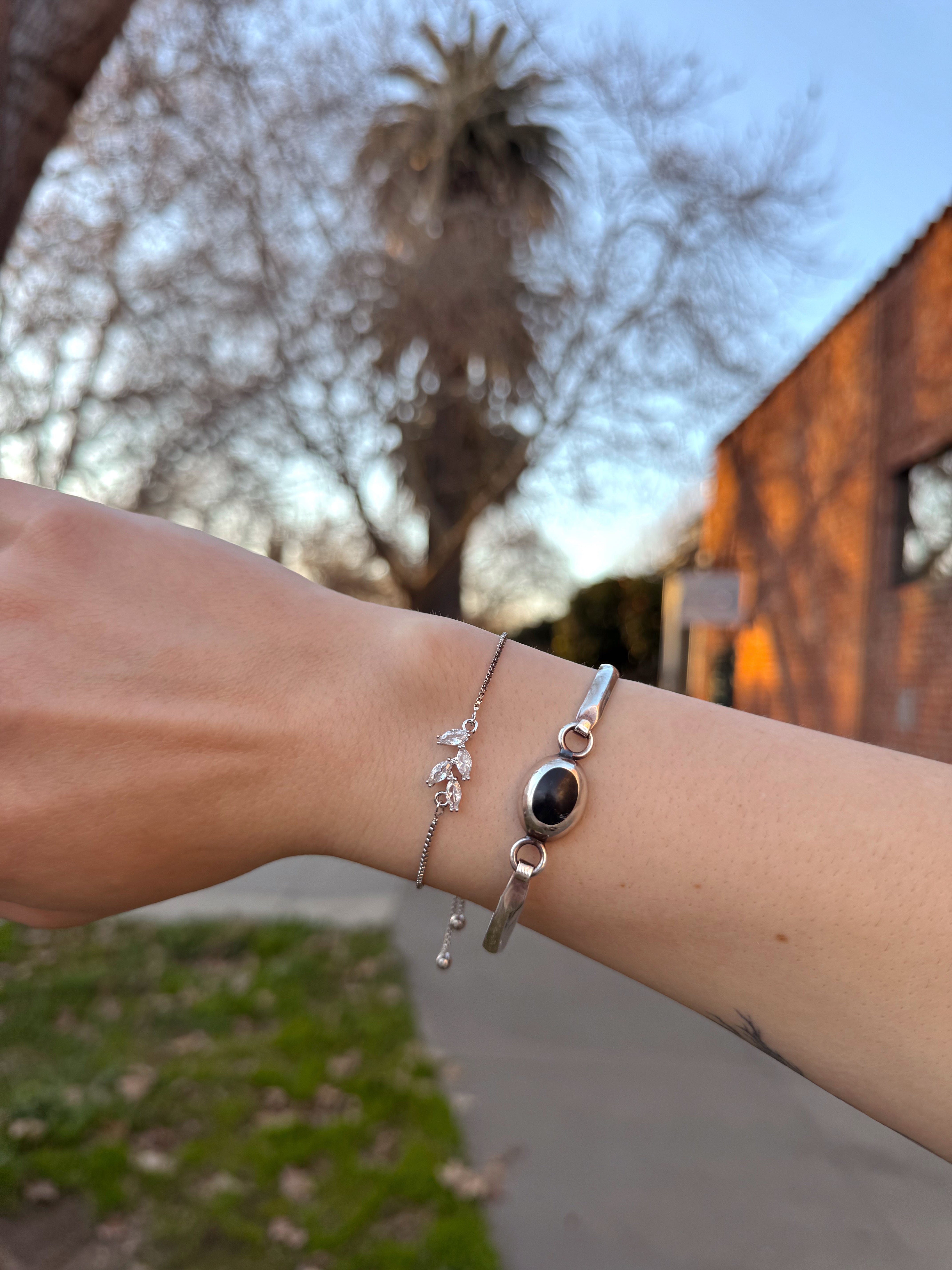 Silver bloom bracelet with floral charm details worn on wrist, minimalist nature inspired jewelry