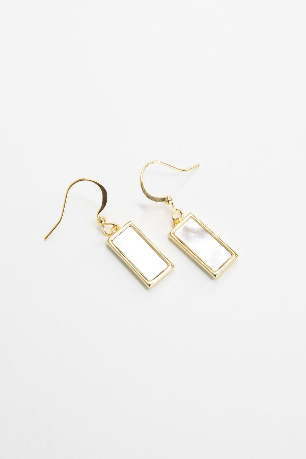 Gold rectangle mother of pearl earrings on white background, minimal and elegant jewelry product shot