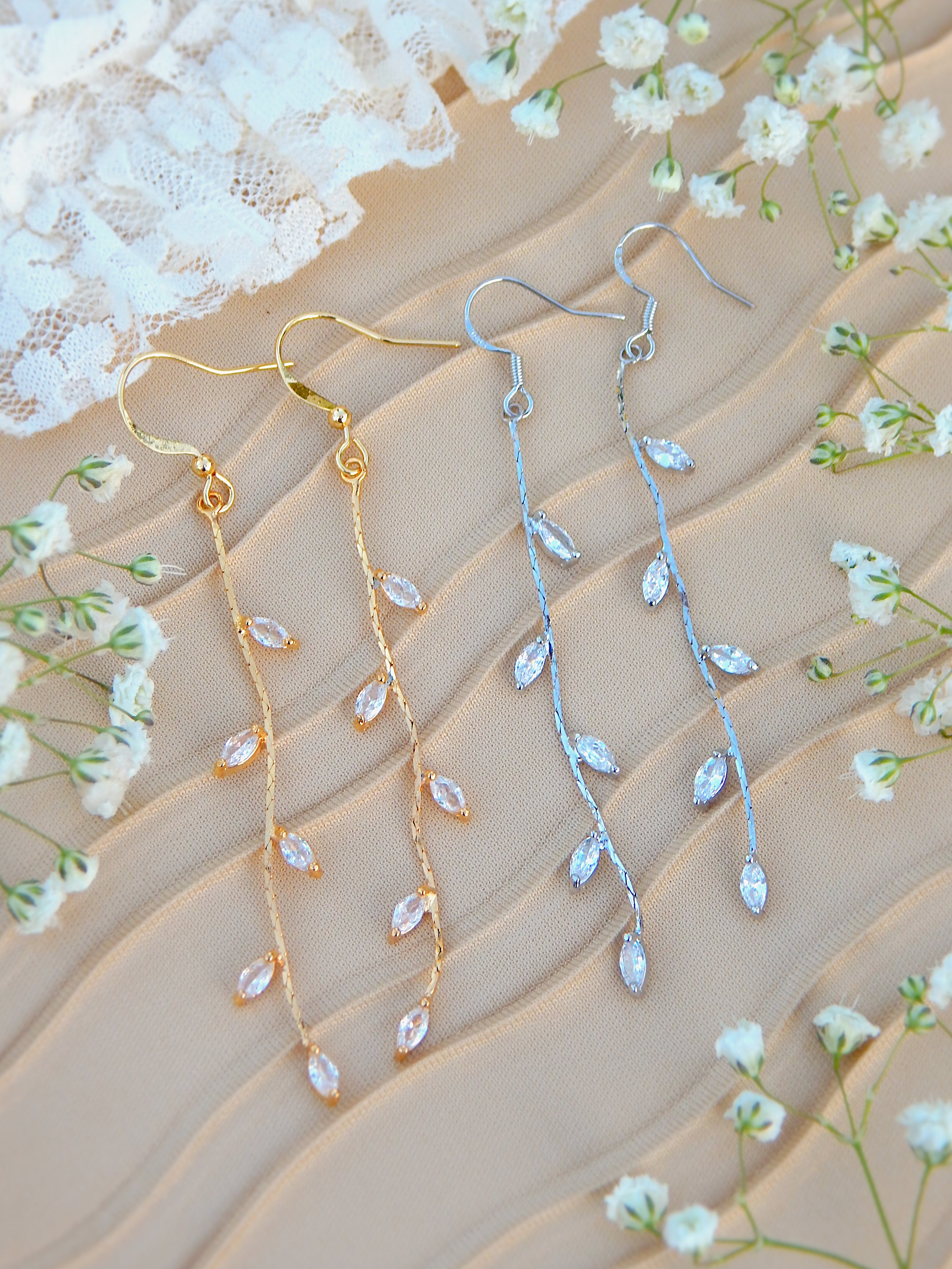 Gold and silver vine drop earrings with leaf details displayed together, showing both color options