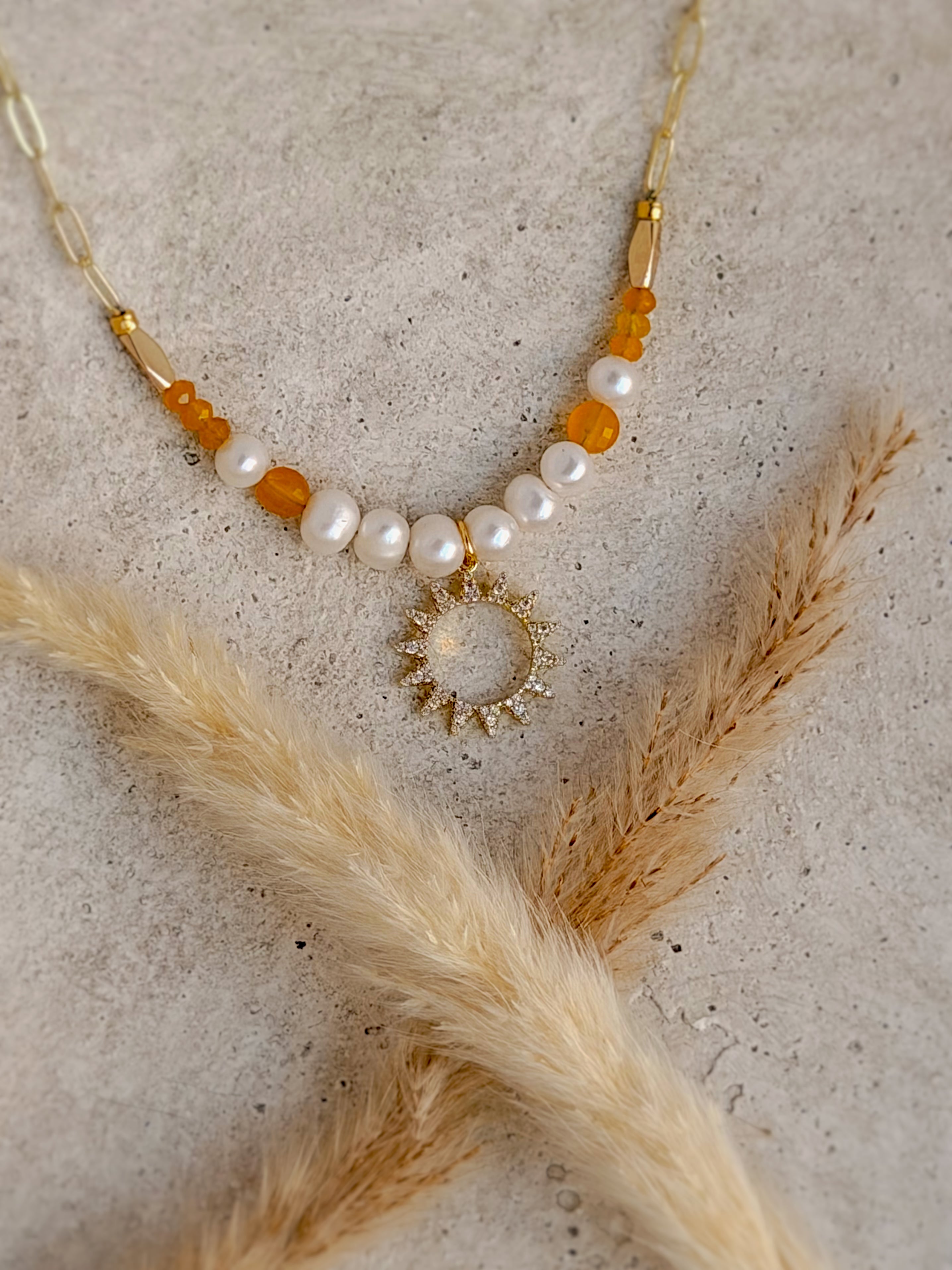 One of a Kind Golden Hour Sun Necklace with freshwater pearls, warm golden gemstones, sparkling crystal sun charm, and gold paperclip chain handcrafted by Rising Soul Jewelry.