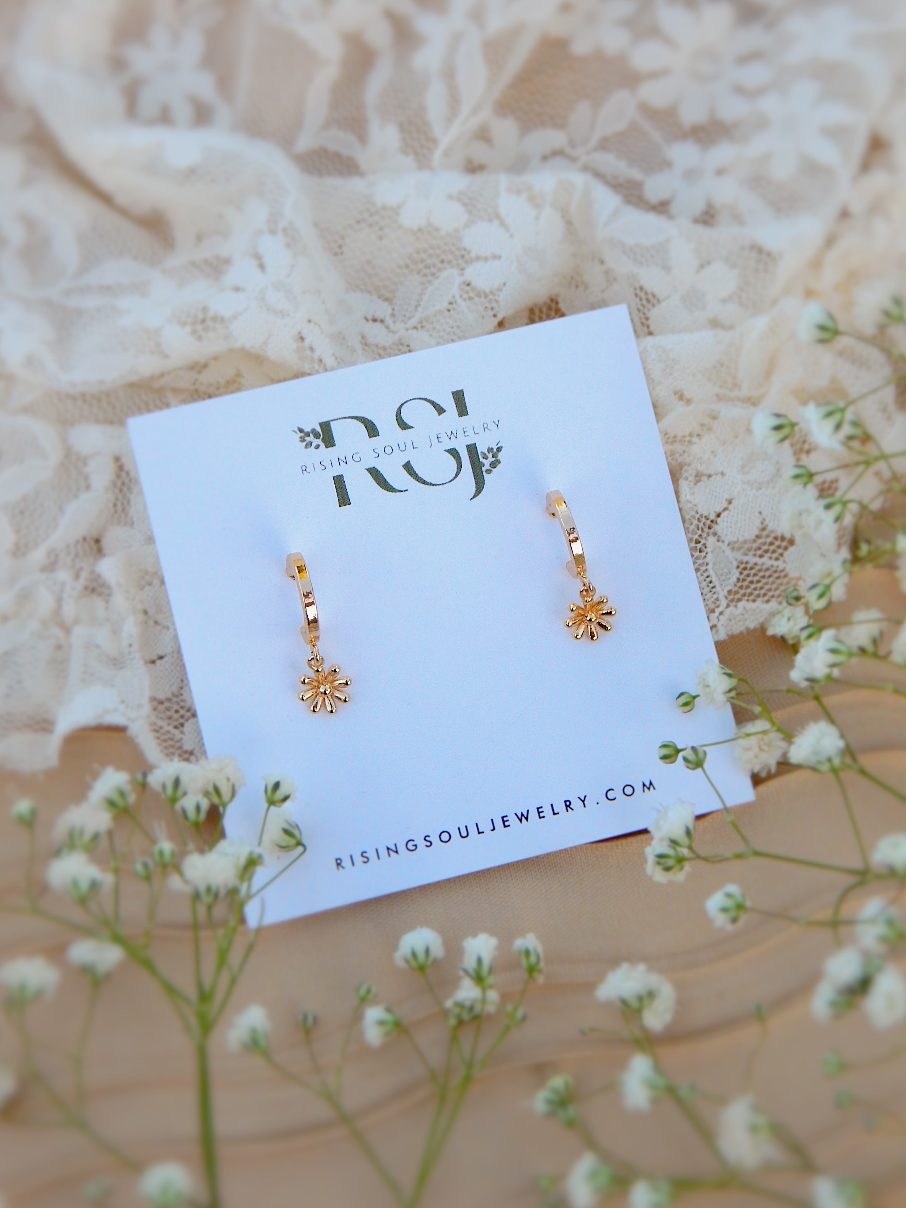 Gold dainty flower drop earrings on jewelry card, minimal floral huggie design