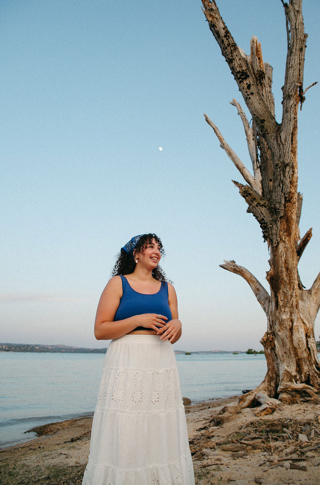 Minimal gold mother of pearl earrings styled with flowy outfit in outdoor beach setting