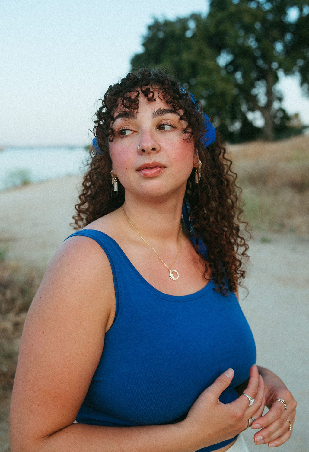Woman wearing gold mother of pearl rectangle earrings in soft natural lighting, showcasing minimal elegant style