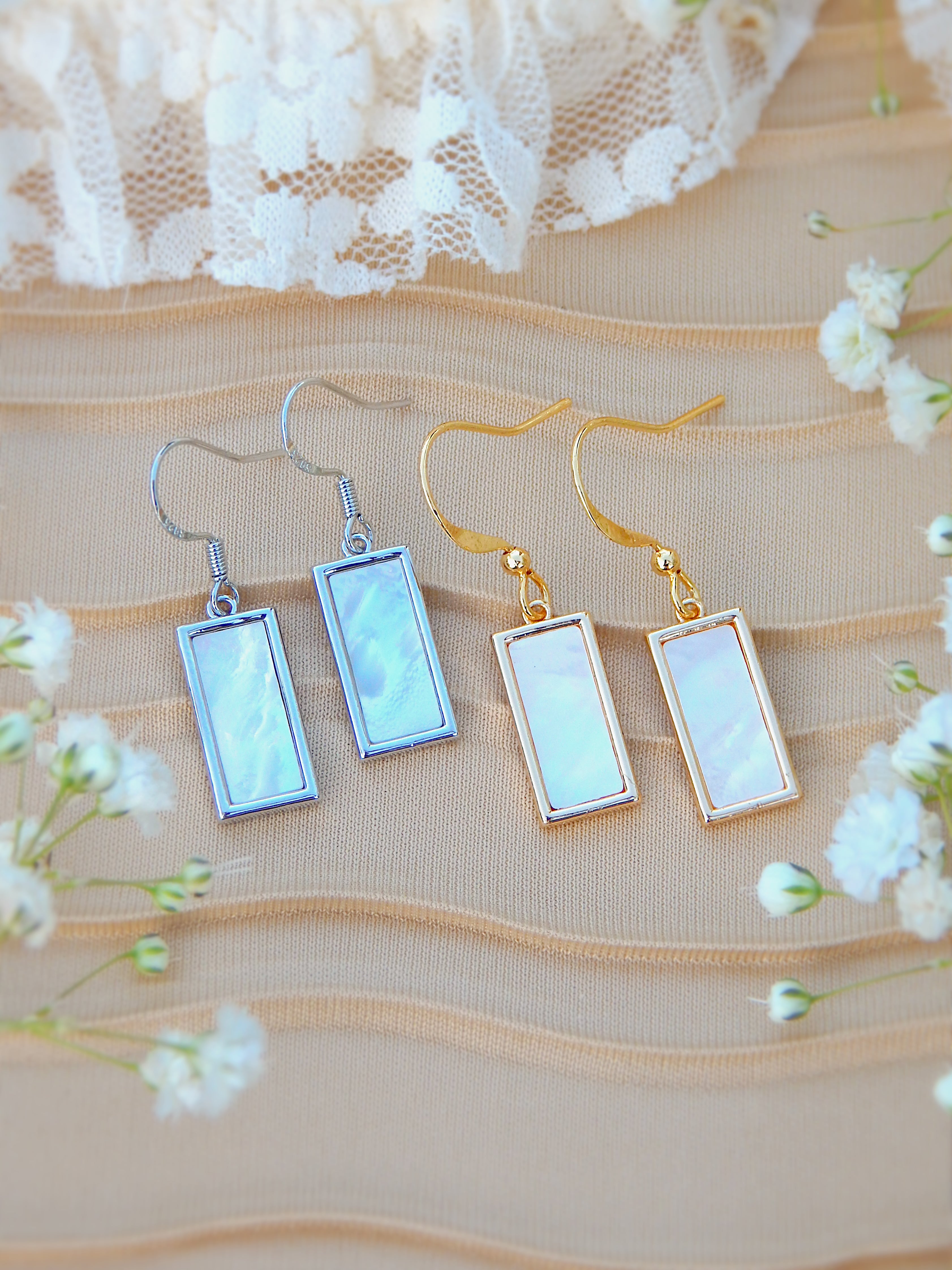 Gold and silver rectangle mother of pearl earrings displayed together, showing both color options in minimal jewelry design