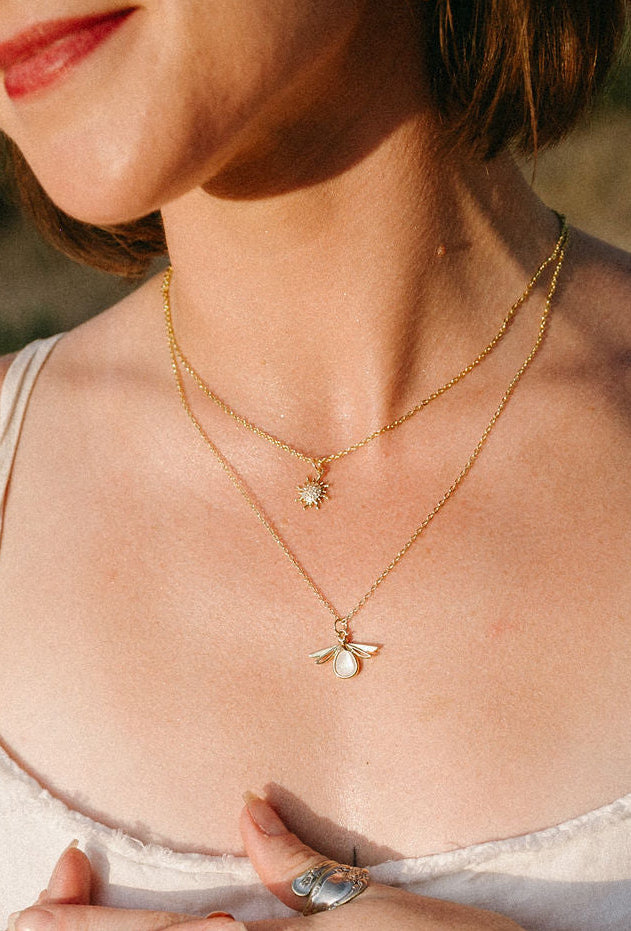 Dawn Necklace styled in a layered gold necklace look with complementary jewelry.
