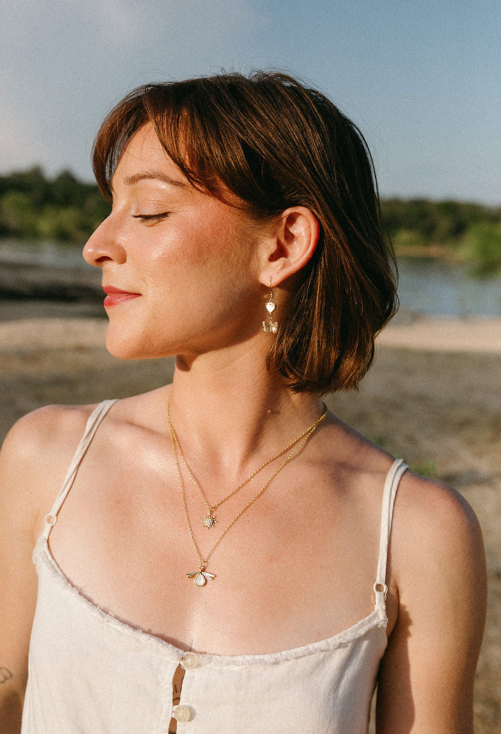 Model wearing the Dawn Necklace outdoors during golden hour, styled with everyday jewelry.
