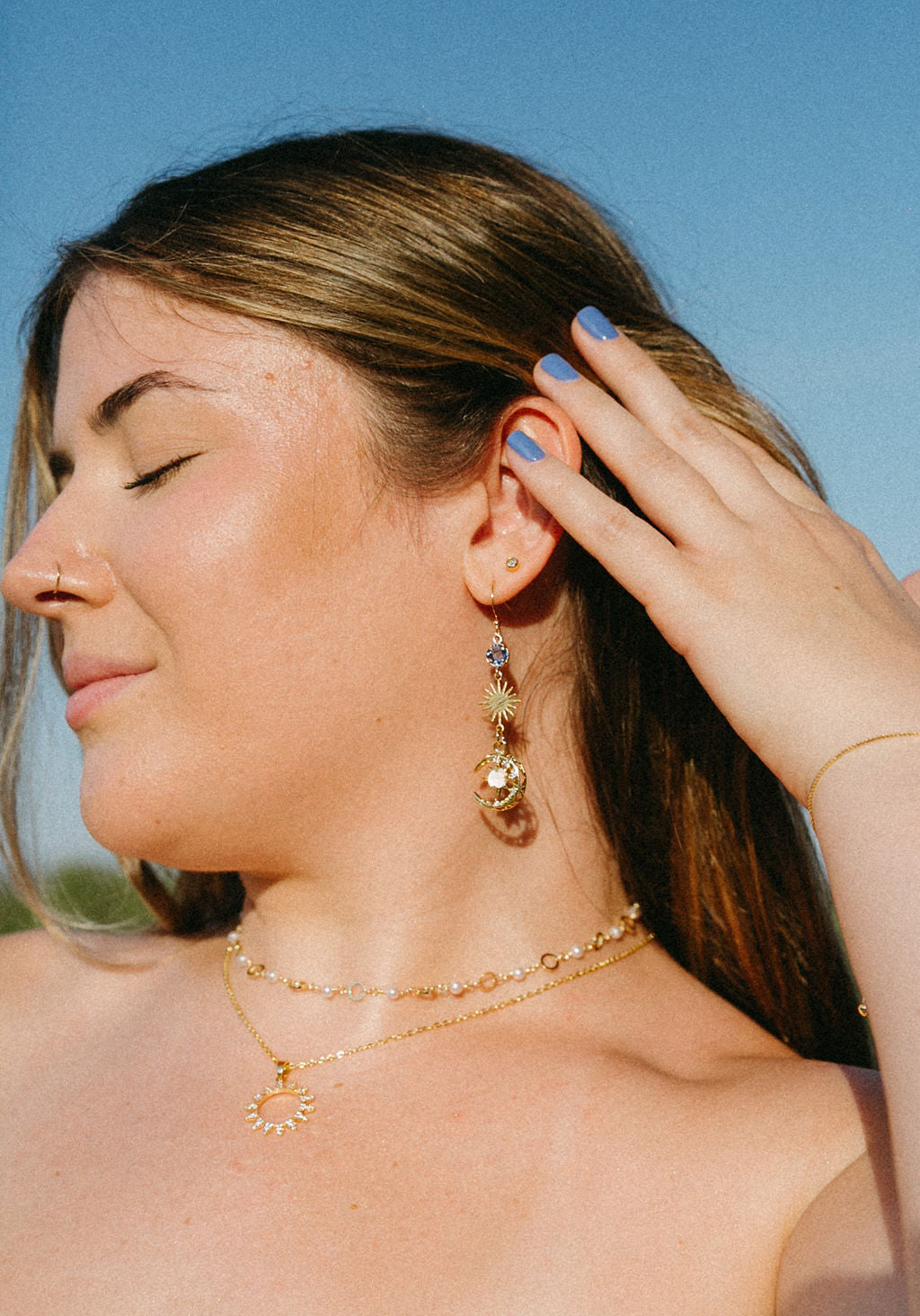 Close-up of model wearing gold CZ sunburst statement necklace