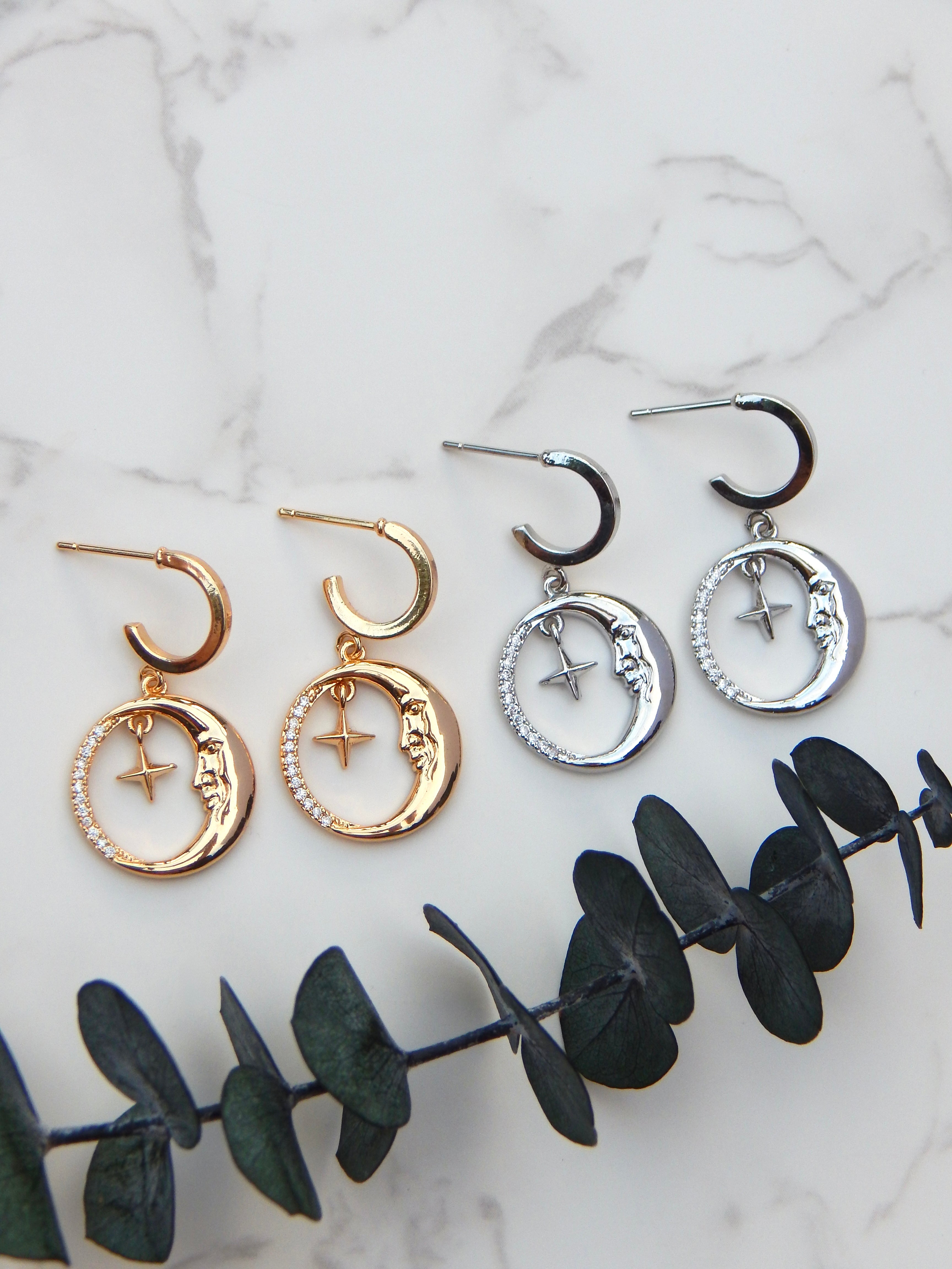 Gold and silver moon and star huggie earrings displayed together showing color options
