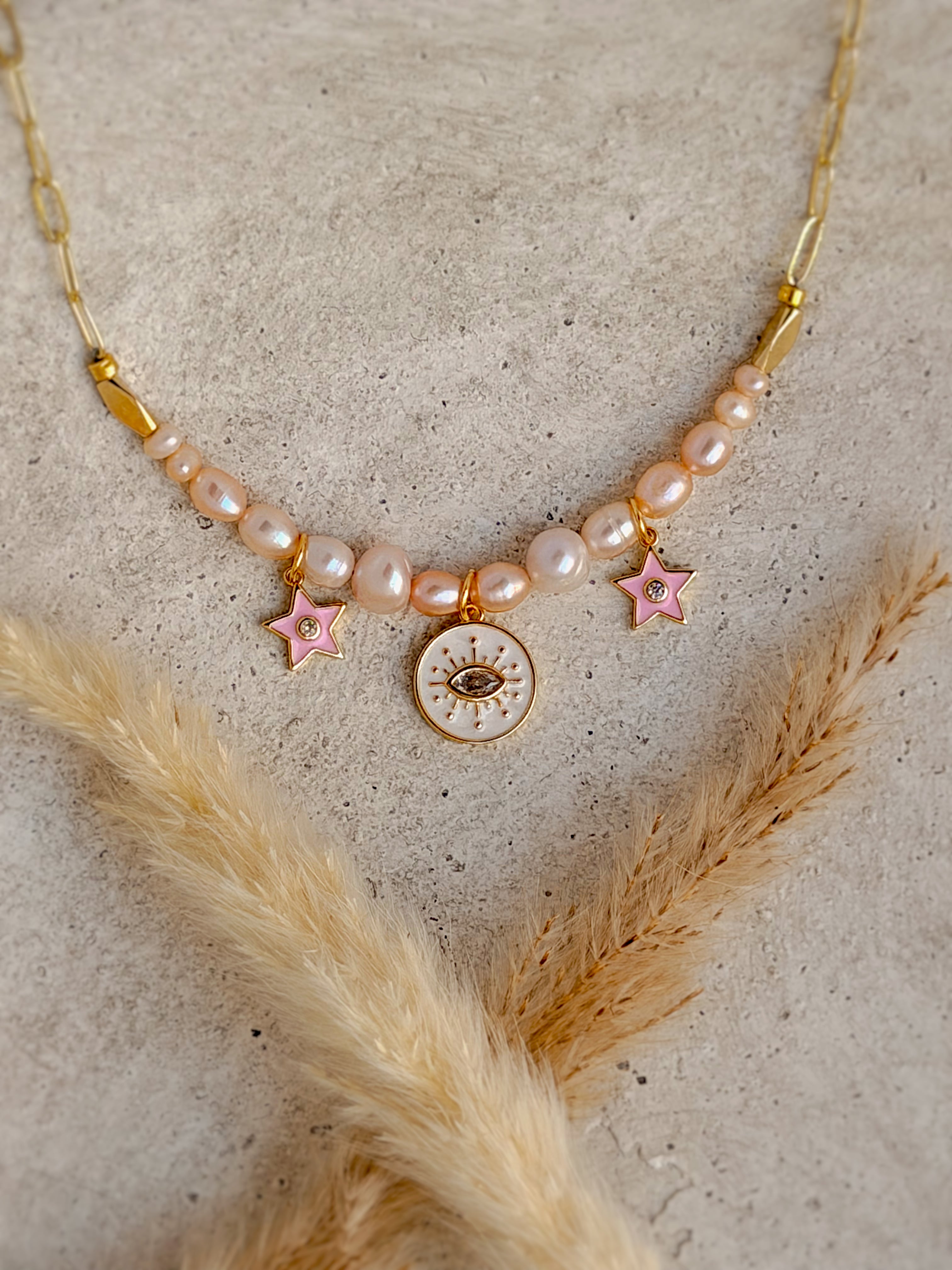One of a Kind Evil Eye Pearl Charm Necklace with freshwater pearls, pink enamel star charms, and gold paperclip chain handcrafted by Rising Soul Jewelry.