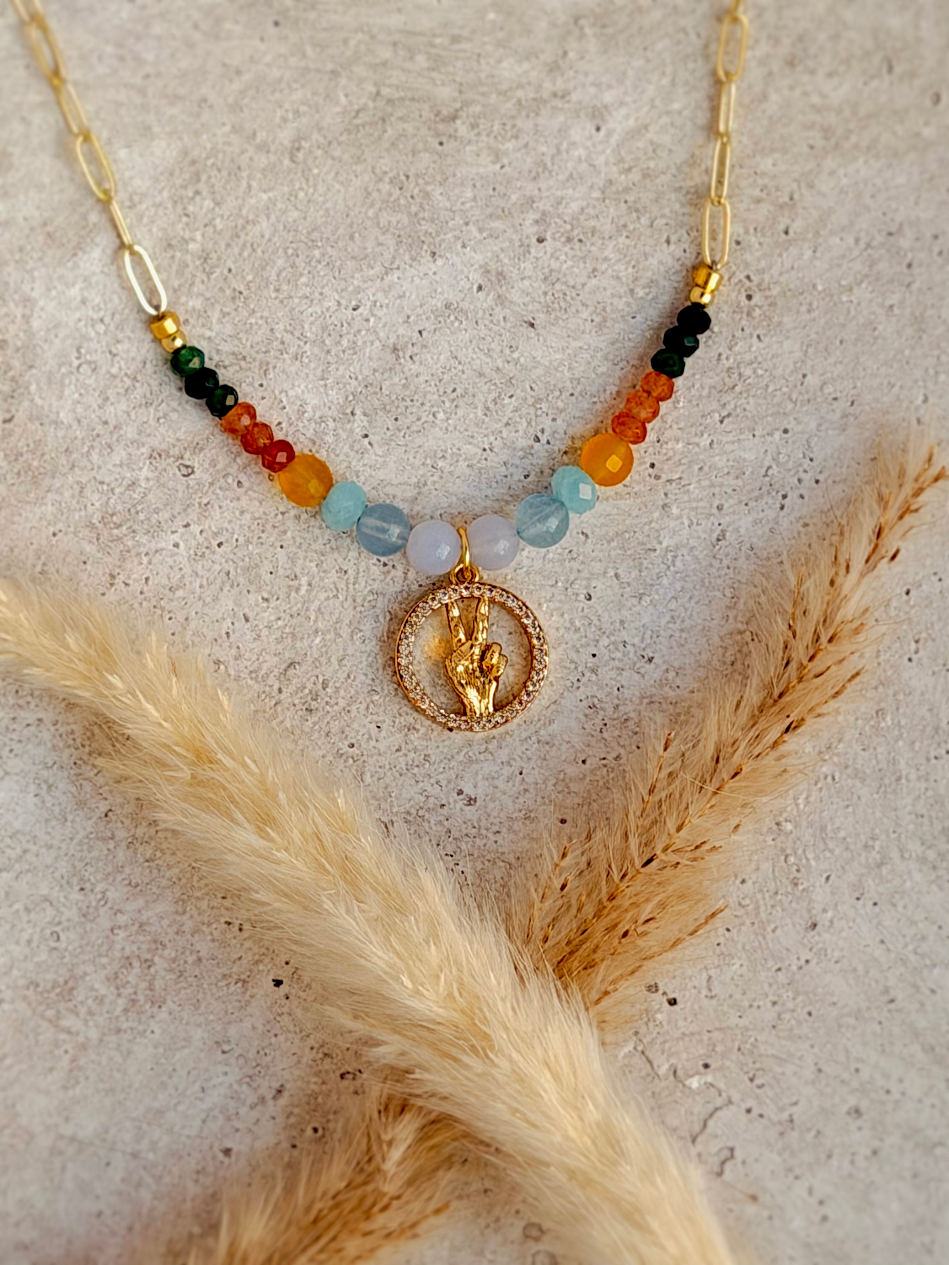 One of a Kind Peace Necklace with colorful natural gemstones, sparkling gold peace hand charm, and gold paperclip chain handcrafted by Rising Soul Jewelry.