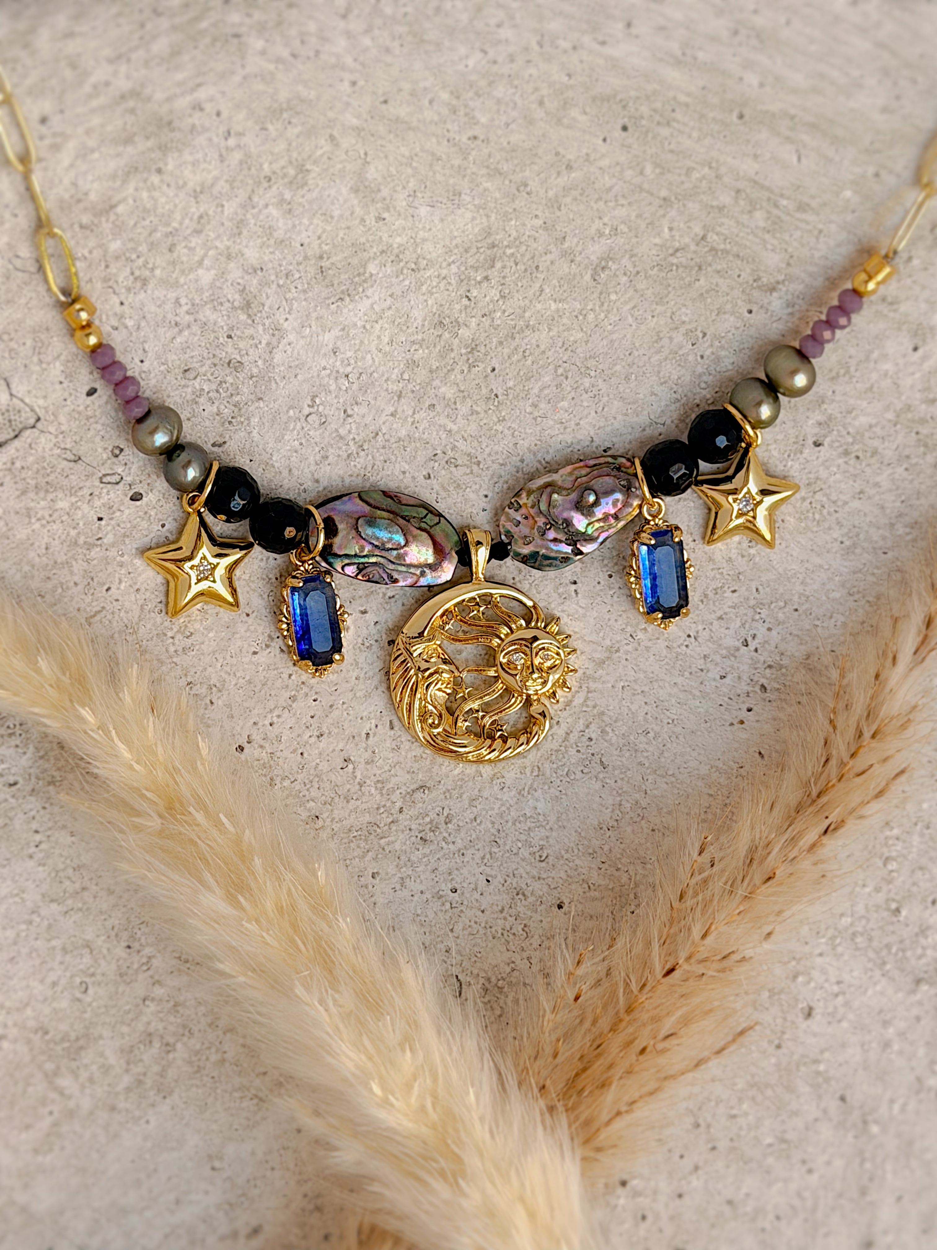 Handmade one-of-a-kind Sun & Moon beaded charm necklace featuring genuine abalone shell, natural gemstones, star charms, blue gemstone accents, and an 18-inch gold paperclip chain by Rising Soul Jewelry.